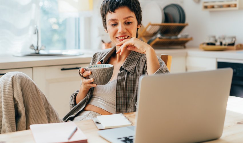 A Young Smiling Woman Sitting In The Kitchen Uses 2023 04 11 16 20 57 Utc